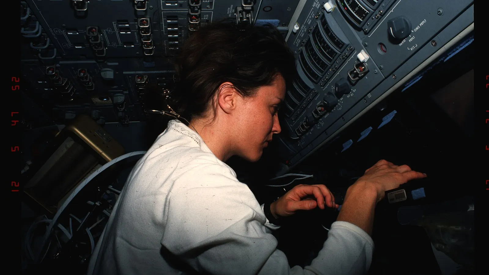Astronaut operating a laptop terminal on the Space Shuttle flight deck