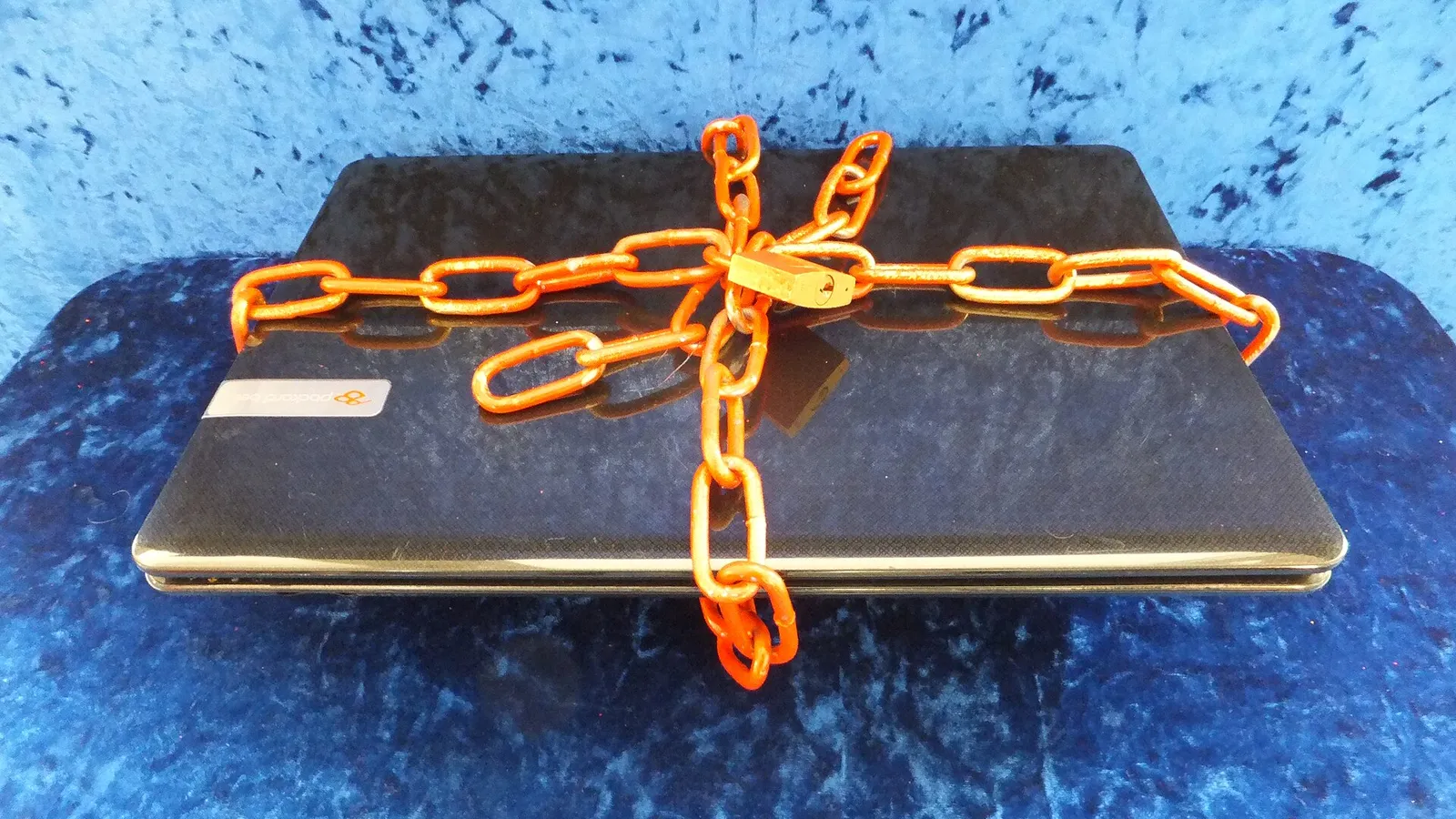 Laptop wrapped in a bright chain and secured with a padlock